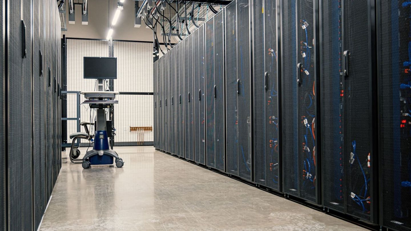 Serverschrank mit strukturiert verlegten Netzwerkkabeln in einem Technikraum